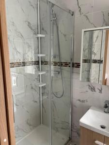 a bathroom with a glass shower with a sink at studio avec terrasse en face la gare d’Enghien a 15 minute de paris gare du nord et a 10 mn de stade de France in Enghien-les-Bains
