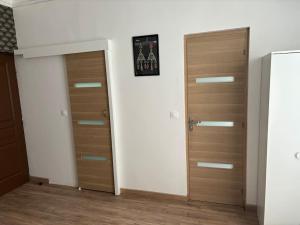 two wooden doors in a room with wooden floors at studio avec terrasse en face la gare d’Enghien a 15 minute de paris gare du nord et a 10 mn de stade de France in Enghien-les-Bains