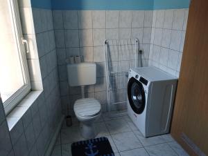 a bathroom with a toilet and a washing machine at Stadtblick 1 Monteuersfreud in Eisenberg +23 photos