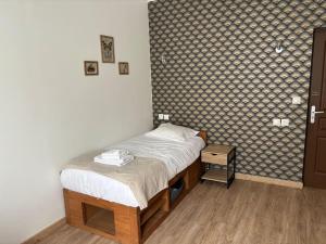 um pequeno quarto com uma cama num quarto em studio avec terrasse en face la gare d’Enghien a 15 minute de paris gare du nord et a 10 mn de stade de France em Enghien-les-Bains