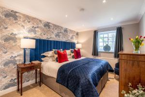 a bedroom with a bed with blue and red pillows at The Old Potting Shed in Richmond