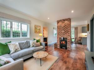 sala de estar con sofá y chimenea en Keeds Cottage, en Pulborough