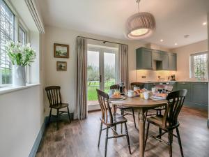 a kitchen and dining room with a table and chairs at Keeds Cottage in Pulborough
