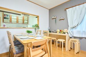 uma cozinha e sala de jantar com uma mesa de madeira e cadeiras em Comfy Home Koiwa em Tóquio