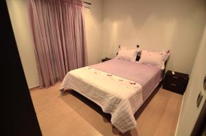 a bedroom with a bed with pink sheets and pillows at Anna's Sea View House in Monemvasia