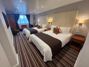 a hotel room with two beds and a desk at Sorrento Hotel & Restaurant in Cambridge
