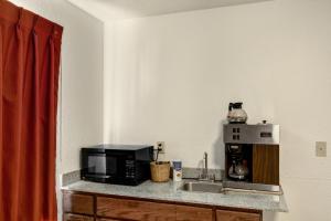 um balcão de cozinha com um micro-ondas e um lavatório em Motel 6-Dallas, TX - South em Dallas