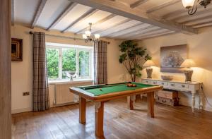 a room with a pool table and a window at Sun Hill Cottage in Leyburn
