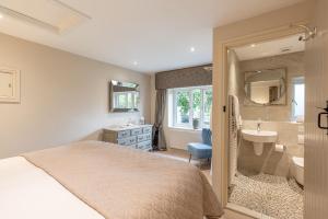 a bedroom with a bed and a sink and a bathroom at Sun Hill Cottage in Leyburn +24 photos
