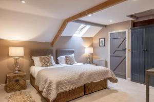 a bedroom with a large bed and a skylight at Sun Hill Cottage in Leyburn