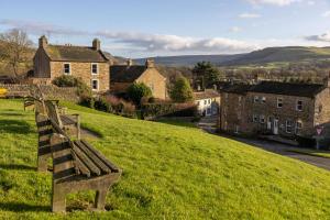 a bench sitting on top of a grassy hill at Sun Hill Cottage in Leyburn