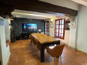 a dining room with a table and chairs and a tv at Barri Antic Cambrils in Cambrils