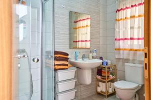 a bathroom with a sink and a toilet and a shower at Seafront Townhouse in Birzebbuga in Birżebbuġa