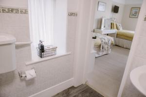 a bathroom with a sink and a toilet and a bed at Leygreen Farmhouse in Beaulieu