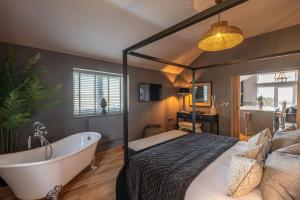 a bedroom with a large bed and a bath tub at Bearskin Cottage in Leyburn