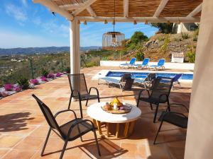 a patio with chairs and a table and a pool at Casa La Aurora in Arenas
