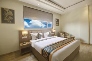um quarto com uma cama grande e uma janela em Hotel King Plaza em Nova Deli