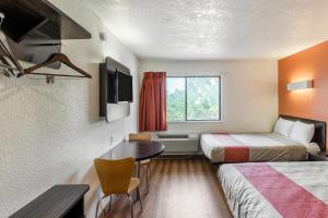 a small hotel room with two beds and a table at Motel 6-Dallas, TX - South in Dallas +54 photos