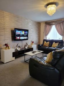 uma sala de estar com um sofá e uma televisão de ecrã plano em Inviting 3-Bed House in Bolton em Bolton