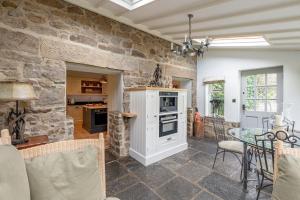 una sala de estar con una pared de piedra en Sun Hill Farmhouse, en Leyburn