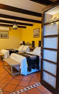 een kamer met 2 bedden en een deur open bij Villa Vicuña Wine & Boutique Hotel in Cafayate