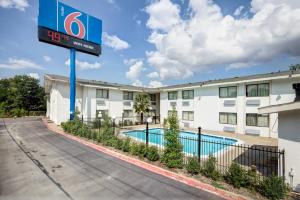 ein Hotel mit einem Pool vor einem Gebäude in der Unterkunft Motel 6-Dallas, TX - South in Dallas