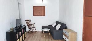 uma sala de estar com um sofá e uma cadeira em La Casilla: Casa acogedora a los pies de la Atalaya. em Níjar