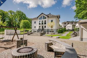 een groot wit huis met een speeltuin ervoor bij Villa Doris Bng 8 Hanau in Heringsdorf