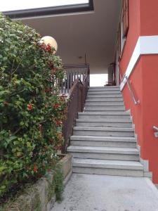 un escalier menant à un bâtiment rouge fleuri dans l'établissement Cjase Paola, à Cassacco