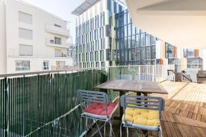 a table and chairs on the balcony of a building at Grand appartement , Paris la Défense Arena, 50 mètres de la gare, 15 min Champs elysées in Nanterre