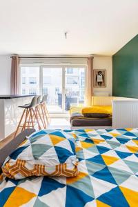 a bedroom with a bed with a colorful quilt at Grand appartement , Paris la Défense Arena, 50 mètres de la gare, 15 min Champs elysées in Nanterre