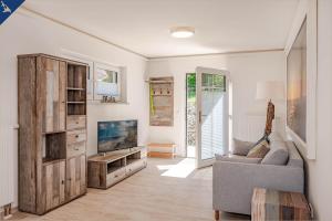 Una sala de estar con un sofá y un televisor. en Villa Doris Whg 6 Morgenrot, en Heringsdorf