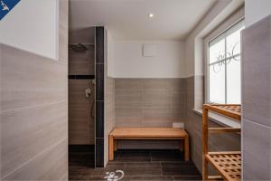y baño con ducha a ras de suelo y banco de madera. en Villa Doris Whg 6 Morgenrot, en Heringsdorf 26 fotos más