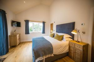 um quarto com uma cama grande e uma janela em Millfield Barn em Richmond