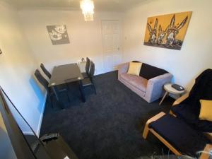a living room with a couch and a chair at 2 Bedroom Modern Apartment in Earl Shilton