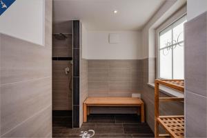 eine ebenerdige Dusche mit einer Holzbank im Bad in der Unterkunft Villa Doris Whg 1 Merilyn in Heringsdorf