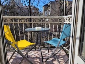 キーウにあるHome Hotel Apartments on Khreshchatyk Areaのバルコニーに椅子2脚とテーブル1台