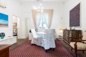 een woonkamer met een witte tafel en stoelen bij Efamoresca in Cagliari