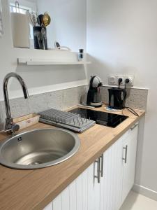 uma cozinha com um lavatório e um teclado num balcão em Ar Maen em Lanvollon