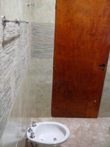 Departamentos por dia EL TREBOL في باسو دي لوس ليبريس: حمام مع حوض وباب خشبي