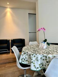 een eetkamer met een tafel met een vaas met bloemen erop bij App De Panne 1 in De Panne