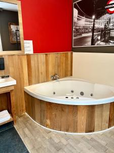 a bath tub in a room with a red wall at App De Panne 1 in De Panne