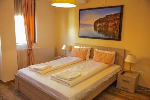a bedroom with a bed with a painting on the wall at Villa Harmony in Ohrid