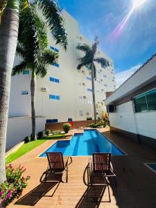 a swimming pool with two chairs next to a building at SHELTON PALACE HOTEL in Paranavaí