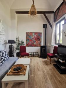 Bénesse-Maremne的住宿－L'antre de l'artiste - Calme & Nature -maisonnette confort，客厅配有蓝色的沙发和红色的椅子