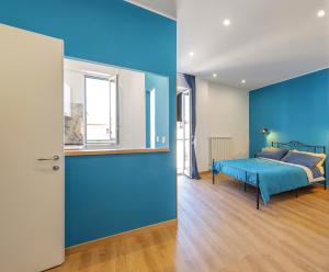 a bedroom with a blue wall and a bed at Casetta Tuscolana in Rome