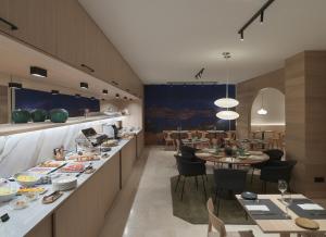 a restaurant with a long counter with tables and chairs at Zenit Coruña in A Coruña