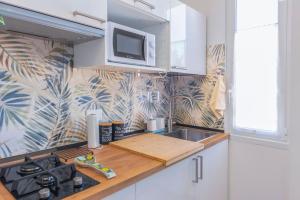 a kitchen with a sink and a stove and a microwave at Casetta Tuscolana in Rome