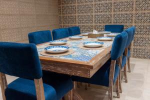 a conference room with a table with blue chairs at منتجع لوشة Loja resort in Buraydah