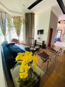 a living room with a blue couch and yellow flowers at SHELTON PALACE HOTEL in Paranavaí